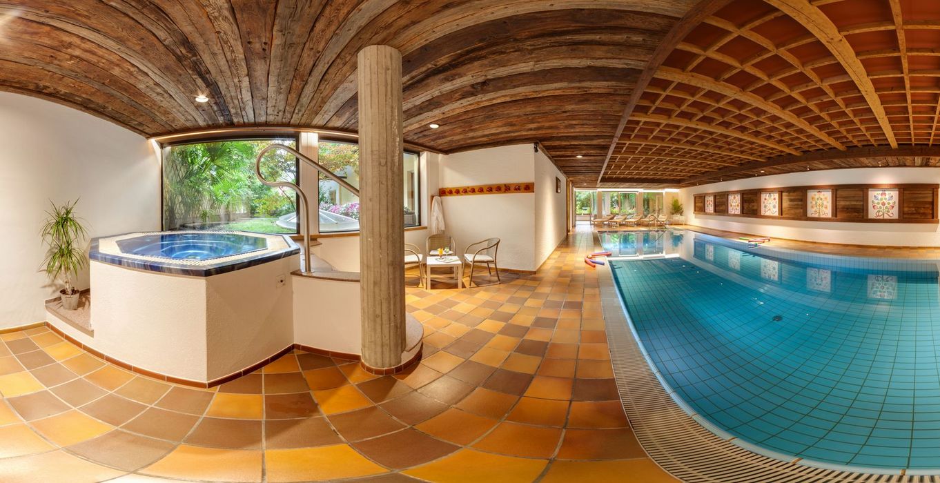 Innenraum mit Schwimmbad und Whirlpool, Holzdecke und gelb-orange gefliester Boden