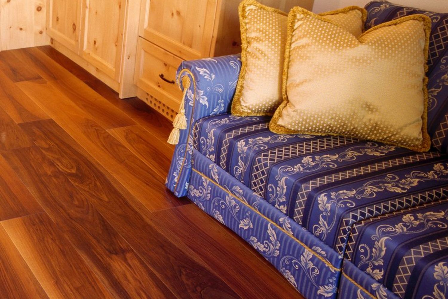 Gemütlicher Essbereich mit runder Holztisch, gepolsterten Stühlen und Sofas, Holzvertäfelungen und braunem Holzboden